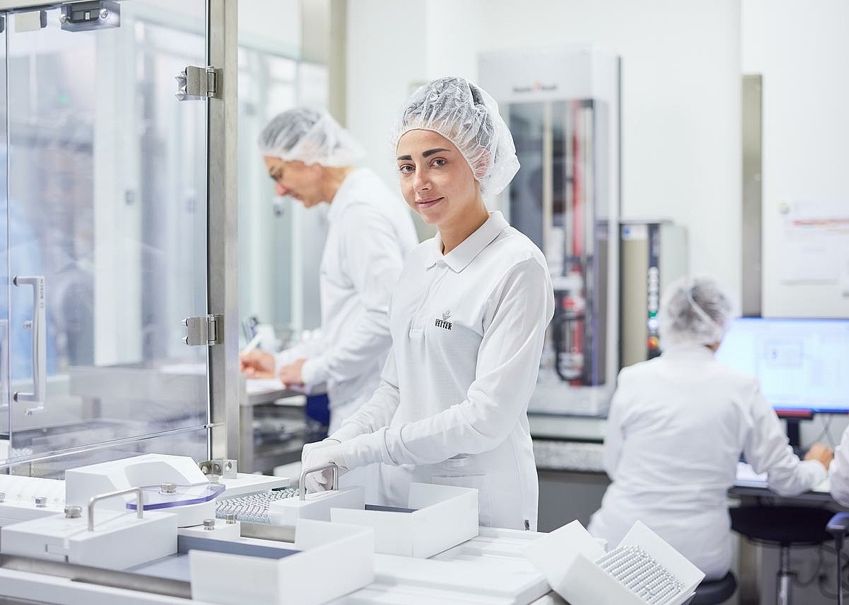 Portraitbild von einer Mitarbeiterin in Laborkleidung 