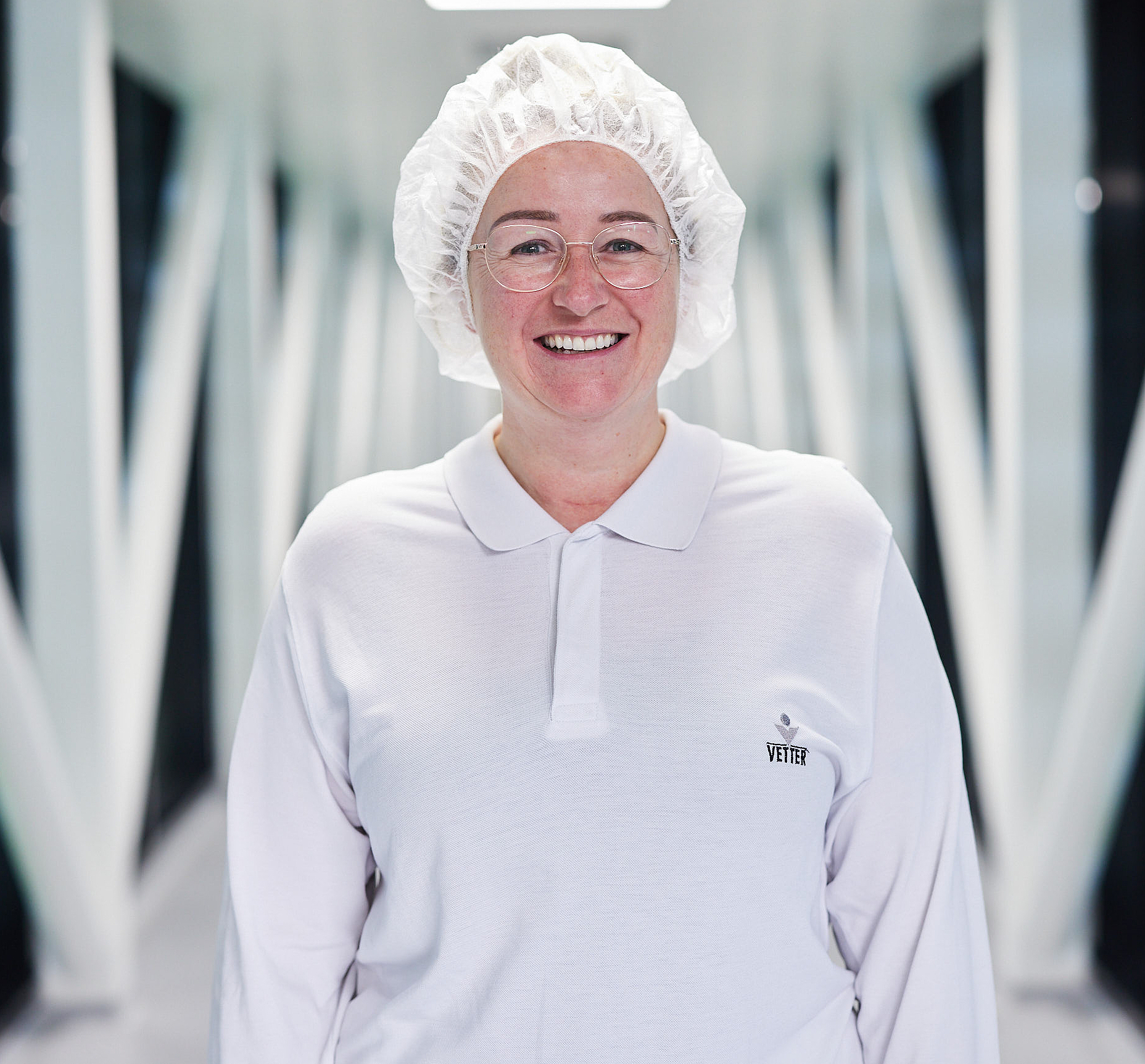 Portraitbild von einer Mitarbeiterin in Laborkleidung