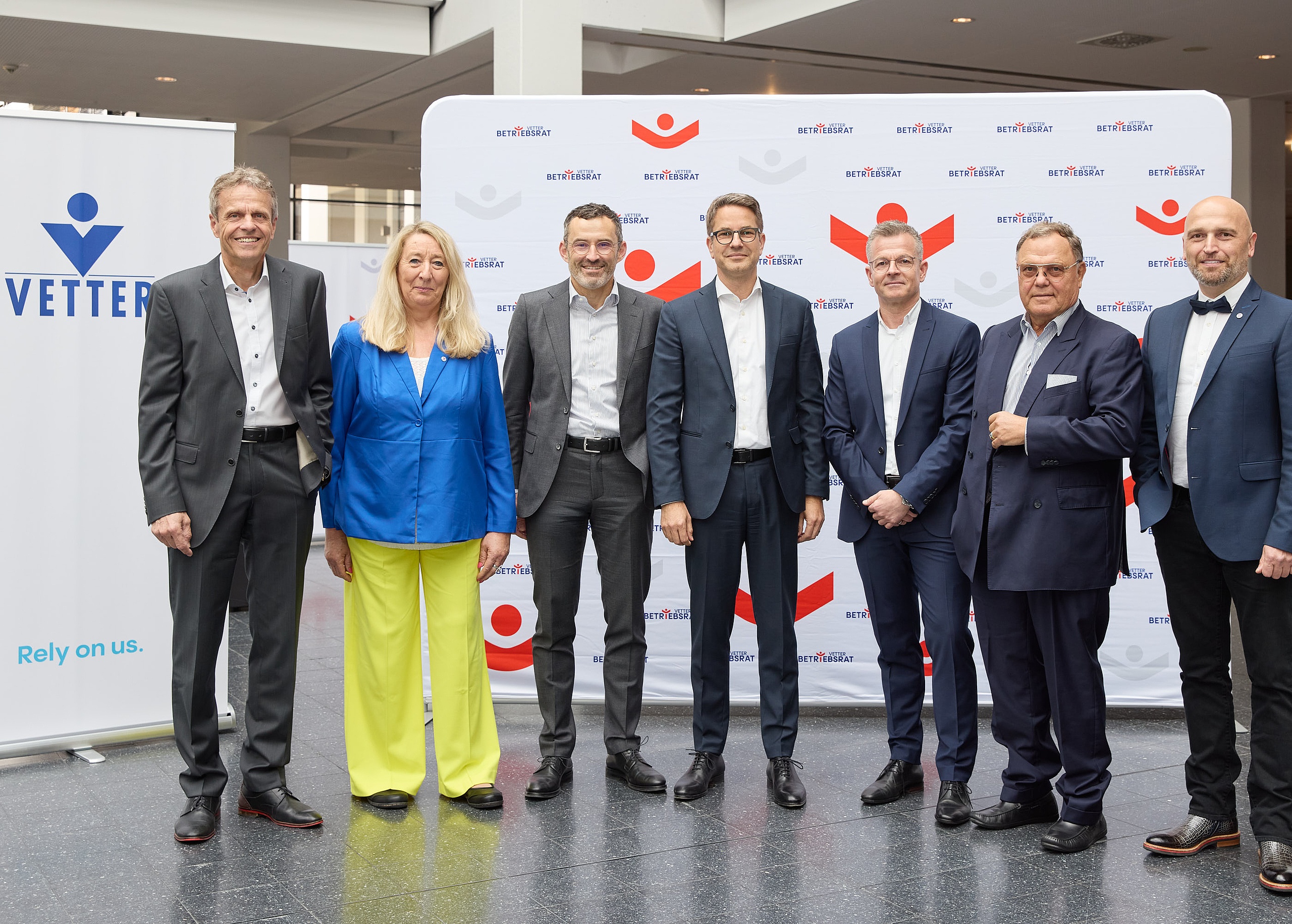 Senator h.c. Udo J. Vetter, Beiratsvorsitzender und Mitglied der  Inhaberfamilie (zweiter von rechts), mit den Geschäftsführern Thomas Otto (erster von links), Titus Ottinger (dritter von links), Carsten Press (vierter von links), Henryk Badack (dritter von rechts), sowie den Betriebsratsvorsitzenden Claudia Schmidt und Aydogan Köse (erster von rechts) bei der Vetter-Betriebsversammlung 2025