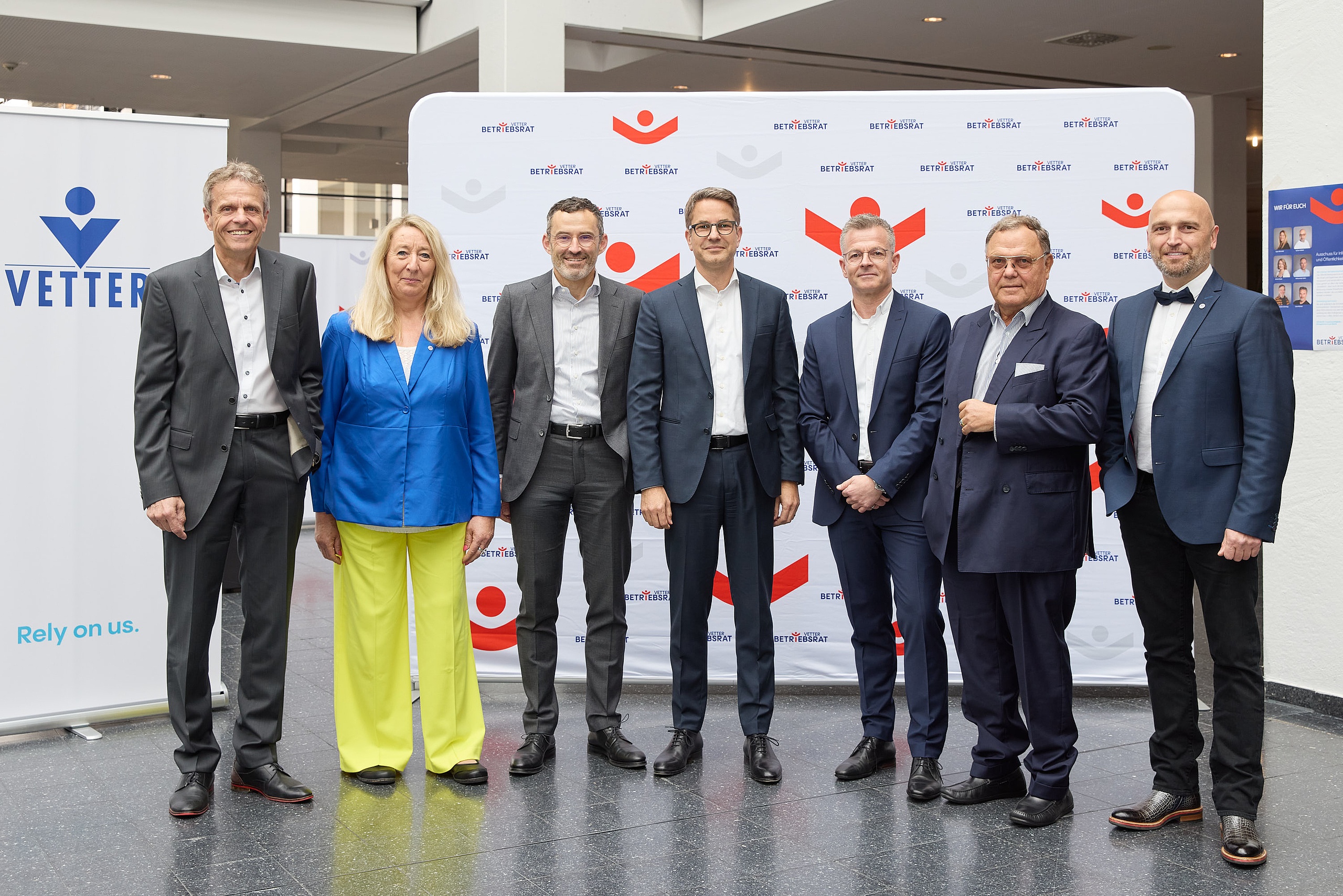 Senator h.c. Udo J. Vetter, Beiratsvorsitzender und Mitglied der  Inhaberfamilie (zweiter von rechts), mit den Geschäftsführern Thomas Otto (erster von links), Titus Ottinger (dritter von links), Carsten Press (vierter von links), Henryk Badack (dritter von rechts), sowie den Betriebsratsvorsitzenden Claudia Schmidt und Aydogan Köse (erster von rechts) bei der Vetter-Betriebsversammlung 2025