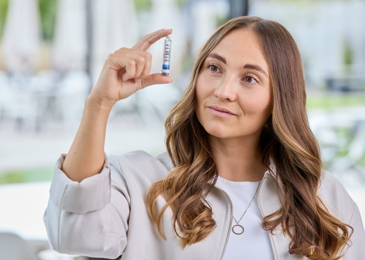 Frau schaut Vial genau an Close-up