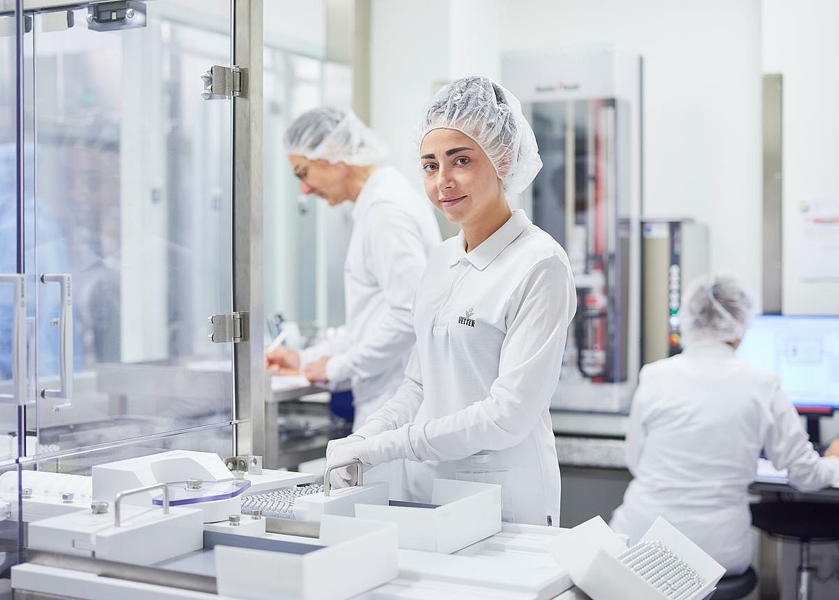 Portraitbild von einer Mitarbeiterin in Laborkleidung 
