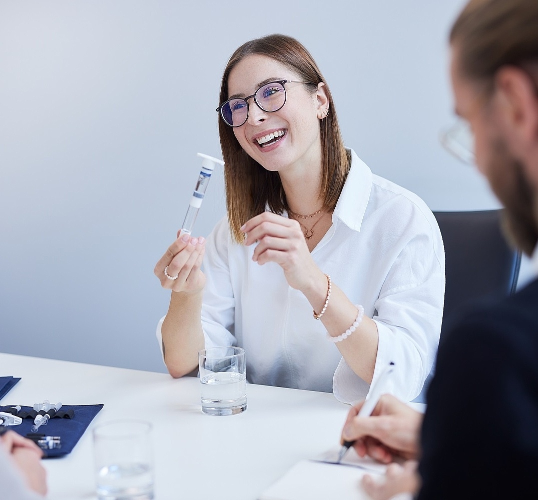 In einem Vorstellungsgespräch bekommt eine Frau eine Spritze von Vetter gezeigt