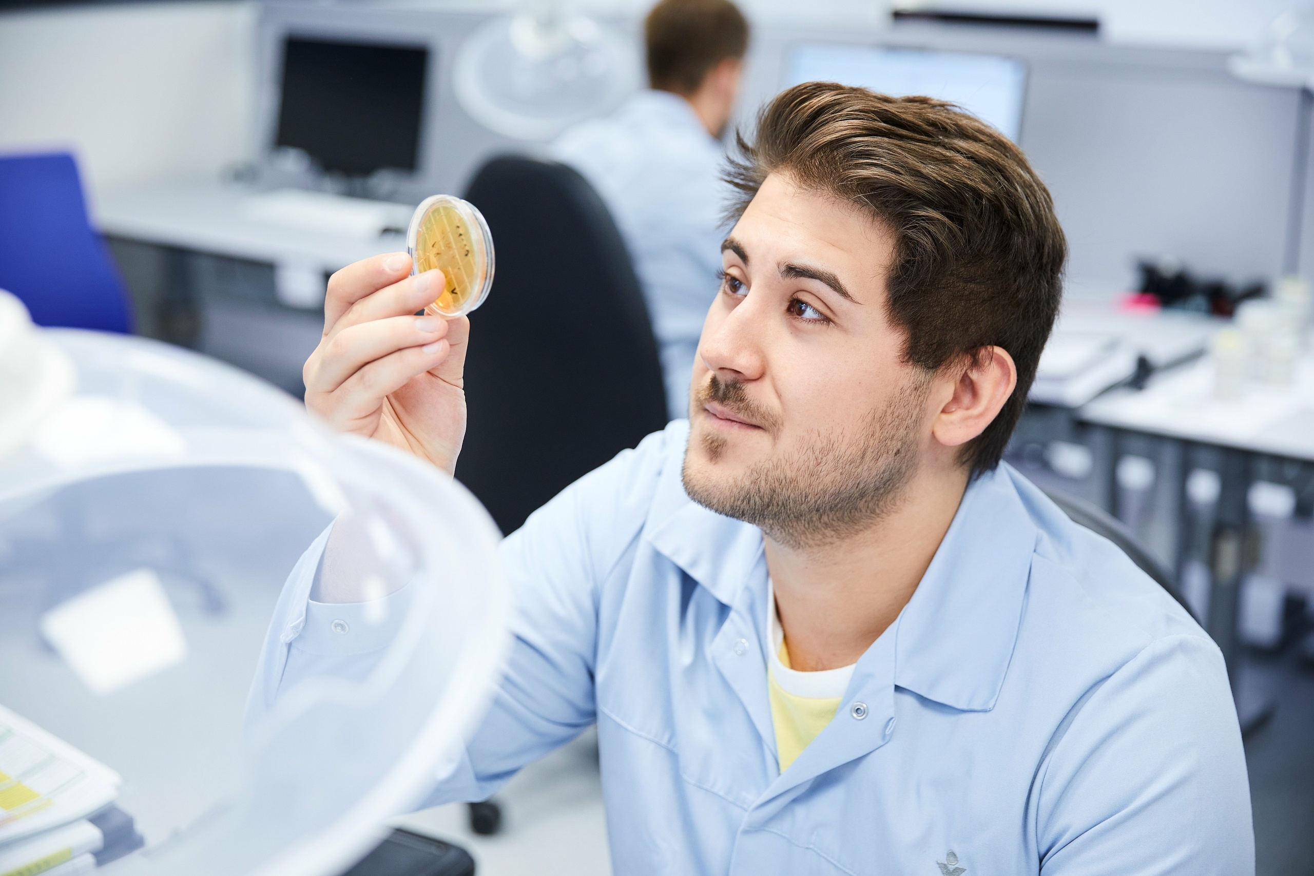 Ein Mitarbeiter in der Mikrobiologie der sich Partikel anschaut 