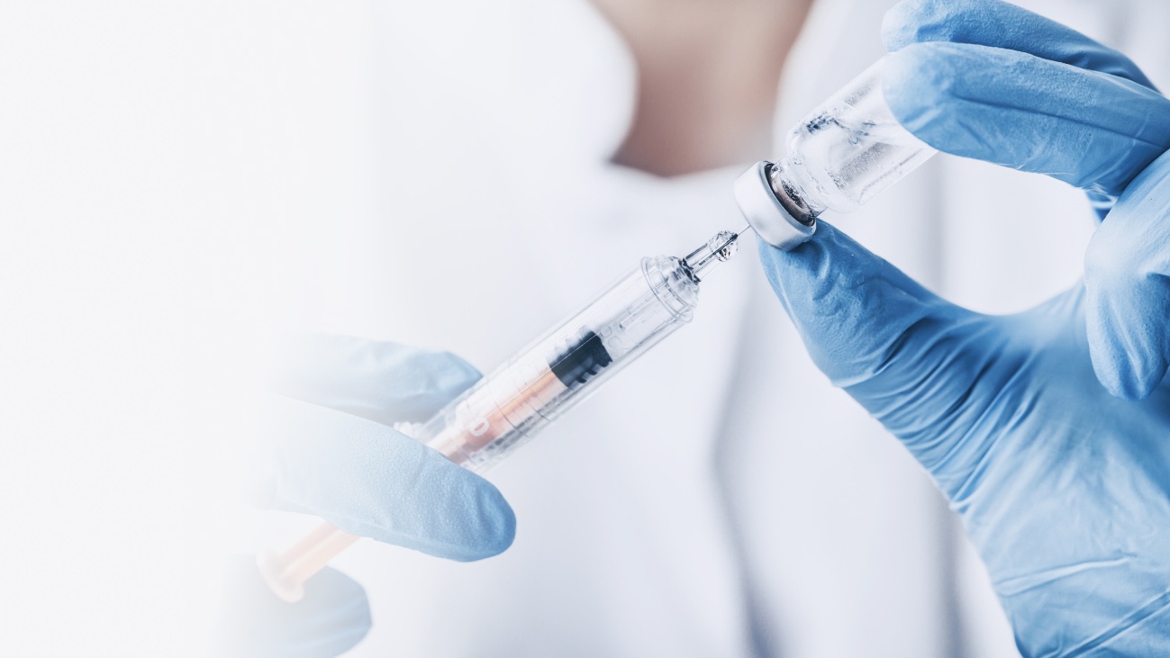 Hands holding a syringe and a vial. 