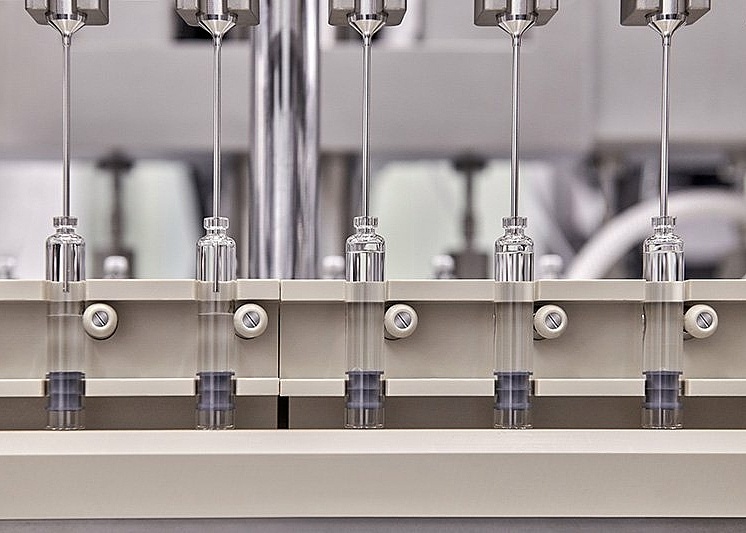 a row of drug product cartridges being filled by a fill finish CDMO