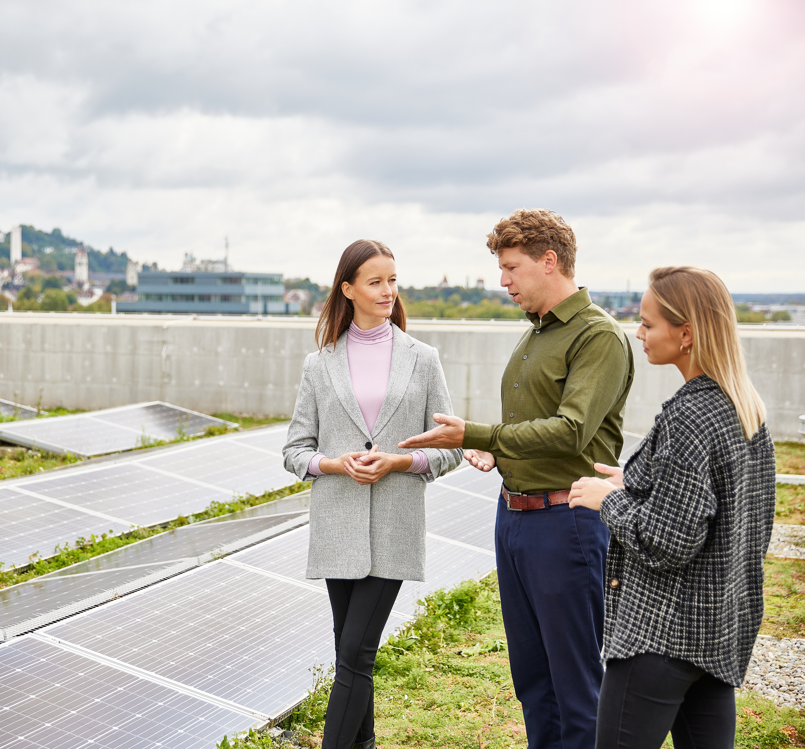 Mitarbeitende auf einem Dach die über die Photovoltaik sprechen 