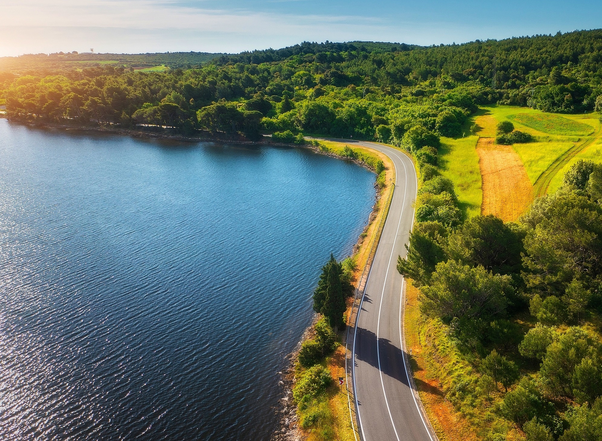Coverbild des Nachhaltigkeitsberichts 2024 von Vetter mit einer Straße, die am Wasser entlangführt