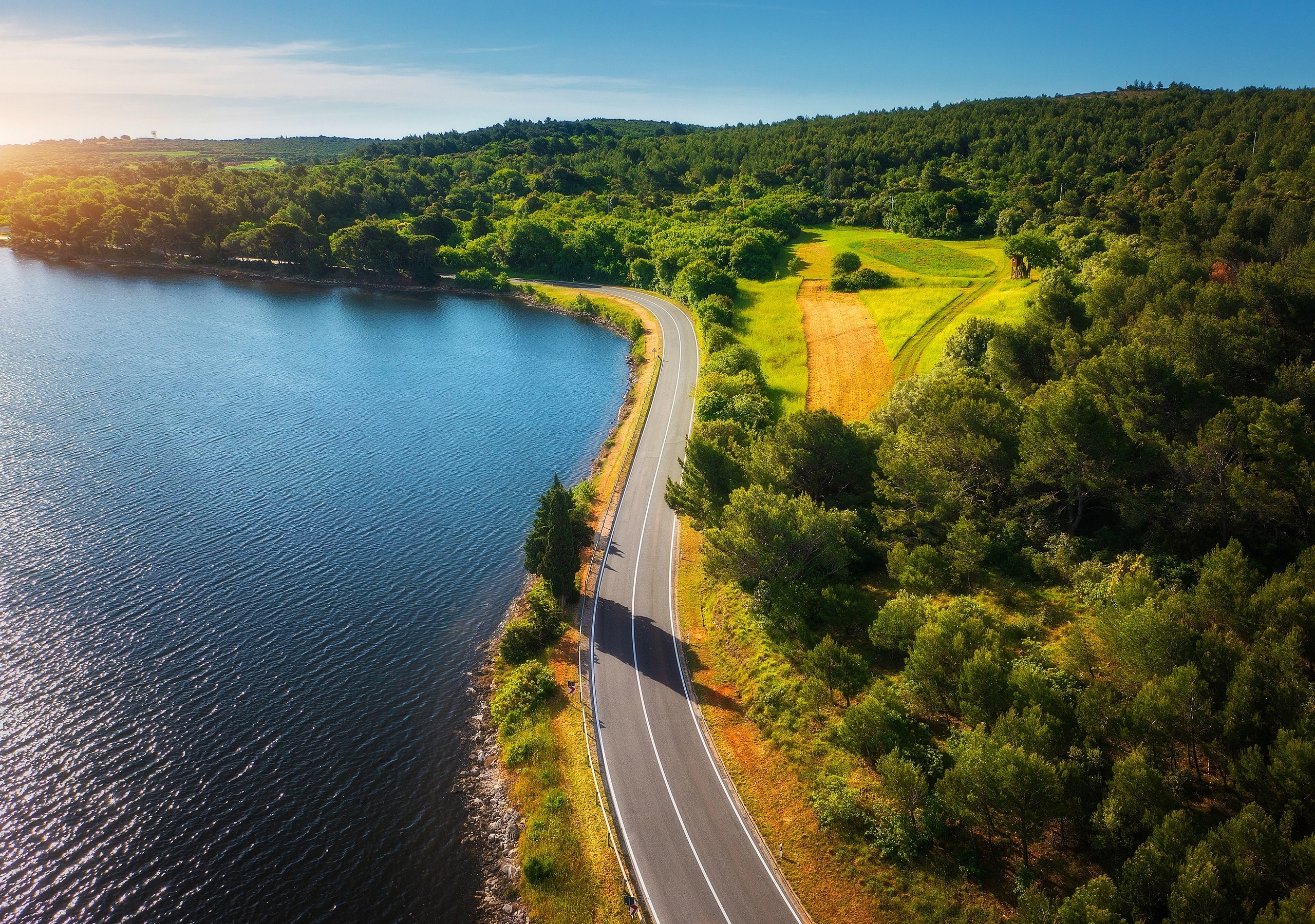 Coverbild des Nachhaltigkeitsberichts 2024 von Vetter mit einer Straße, die am Wasser entlangführt