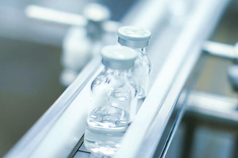Vials of clinical trial material on CDMO filling line