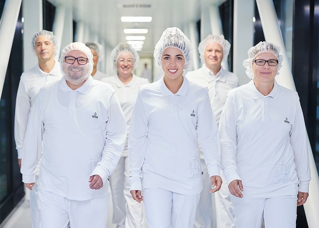 Pharma-Mitarbeitende laufen zusammen einen Flur entlang