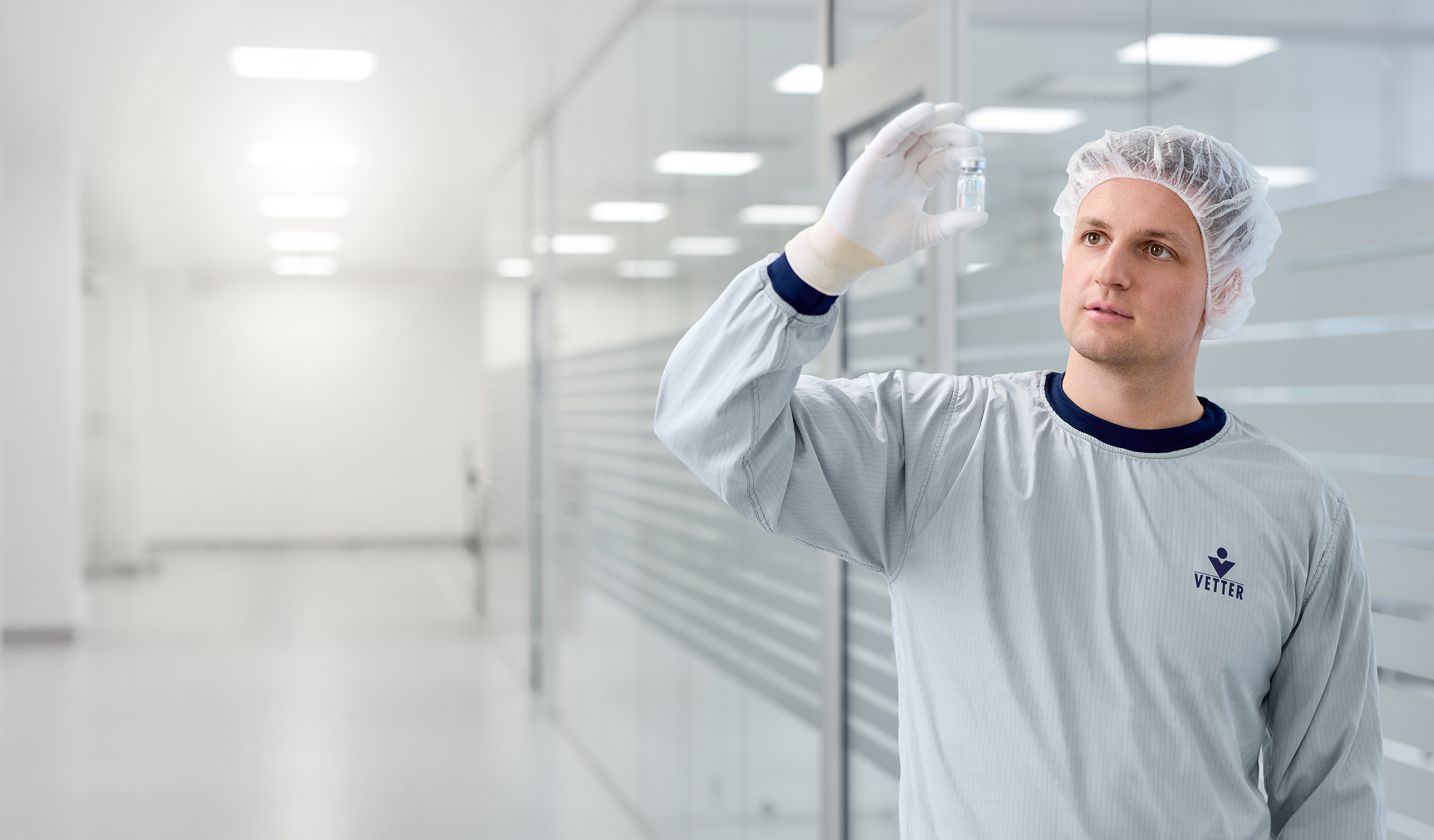 Mann schaut ein Vial genau an