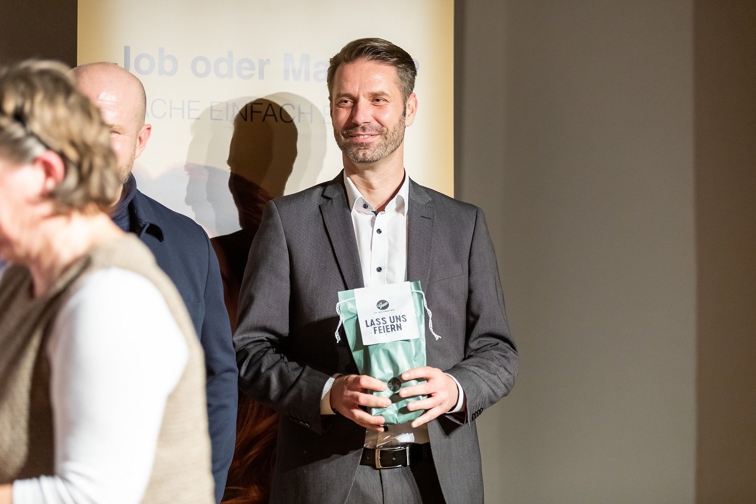 Ein Mann der ein Geschenk in der Hand hält 