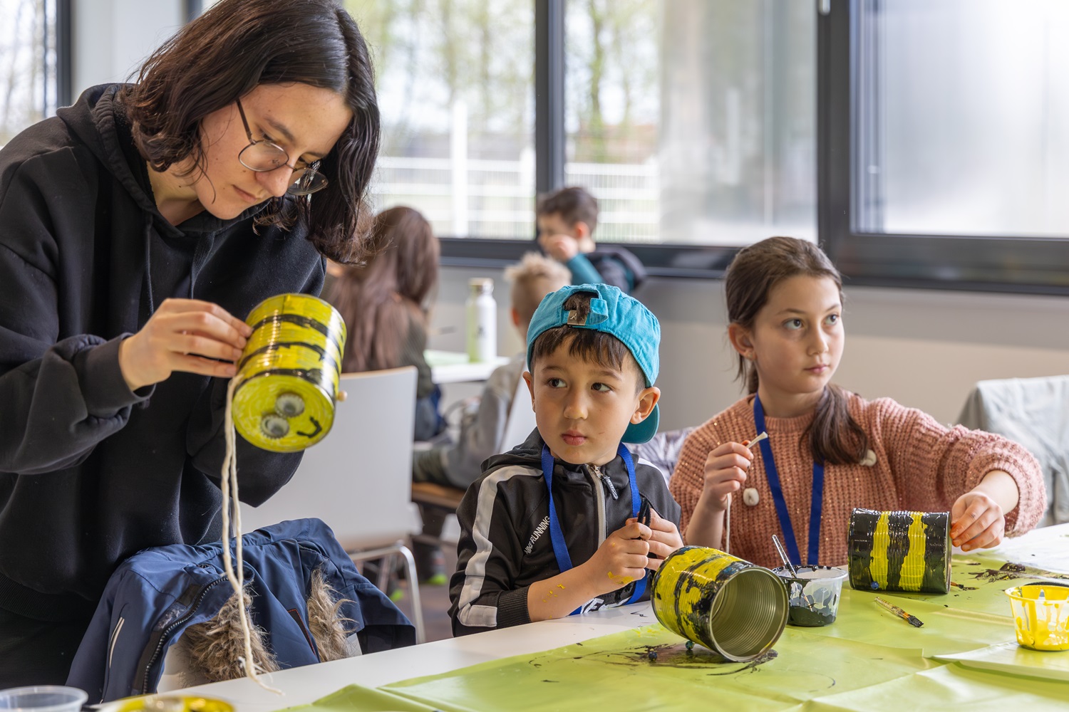 Kinder beim Basteln ihrer Bienen aus Dosen