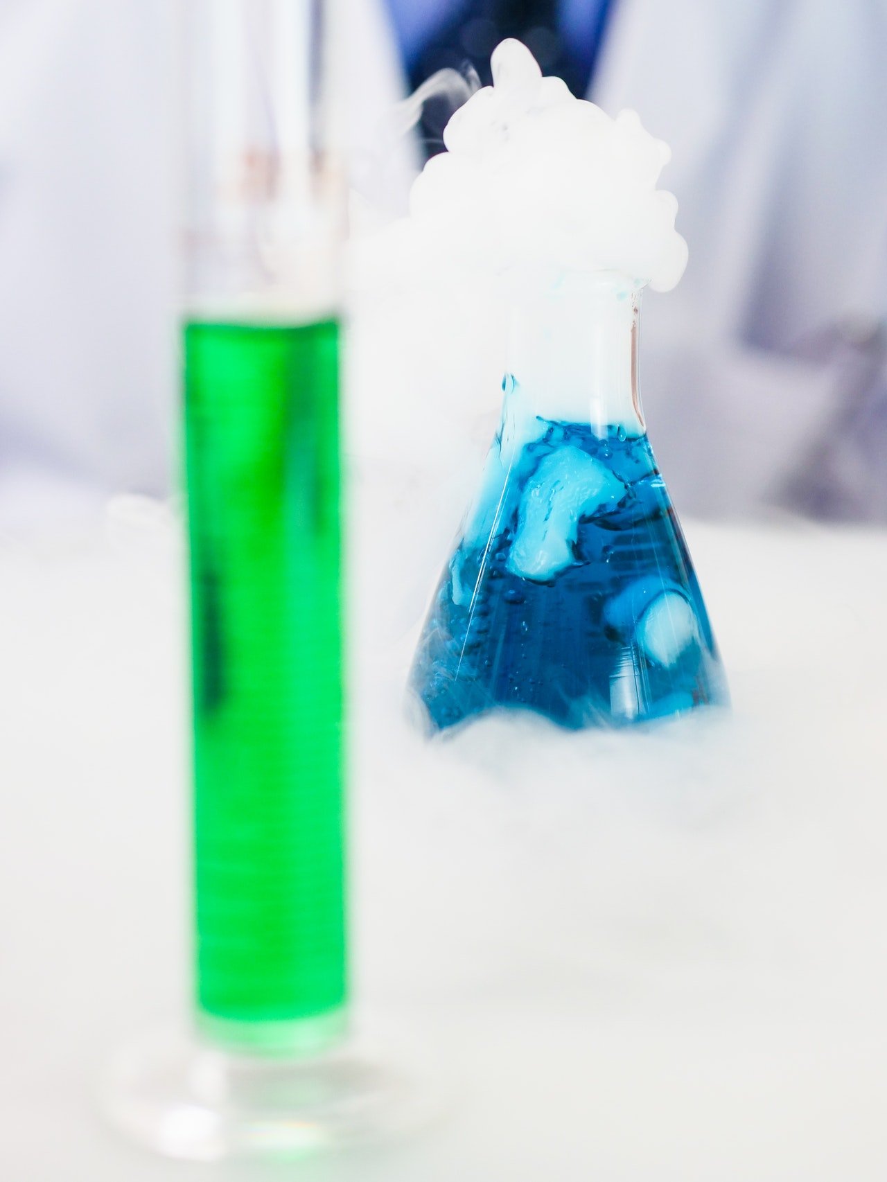 Gefäße mit grüner und blauer Füllung in einem Labor 
