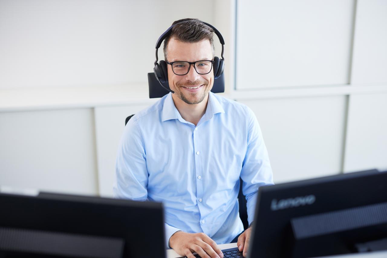 Mitarbeiter der an seinem Arbeitsplatz in der Verwaltung sitzt 