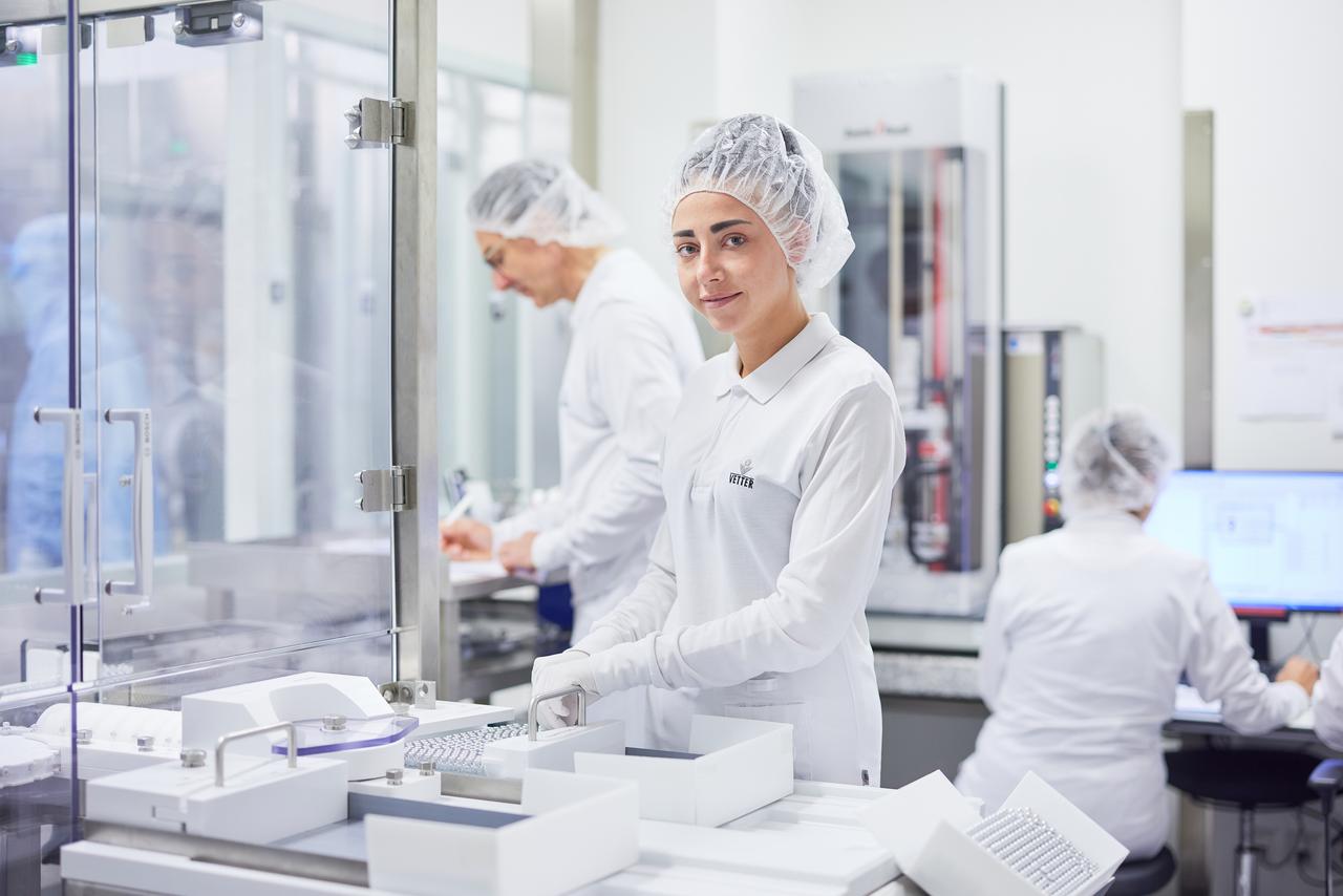 Portraitbild von einer Mitarbeiterin in Laborkleidung 