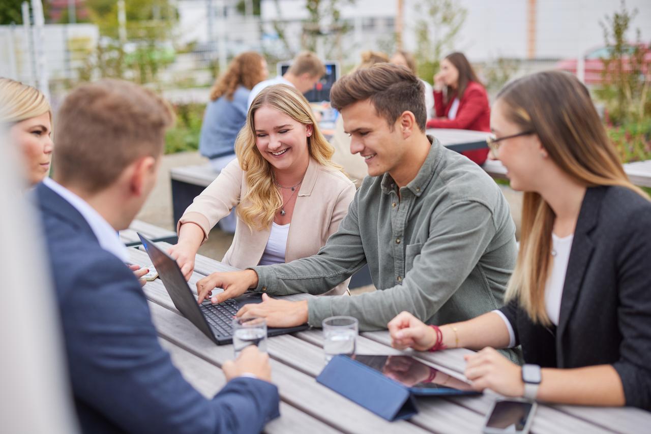 Mitarbeitende die zusammen draußen arbeiten 