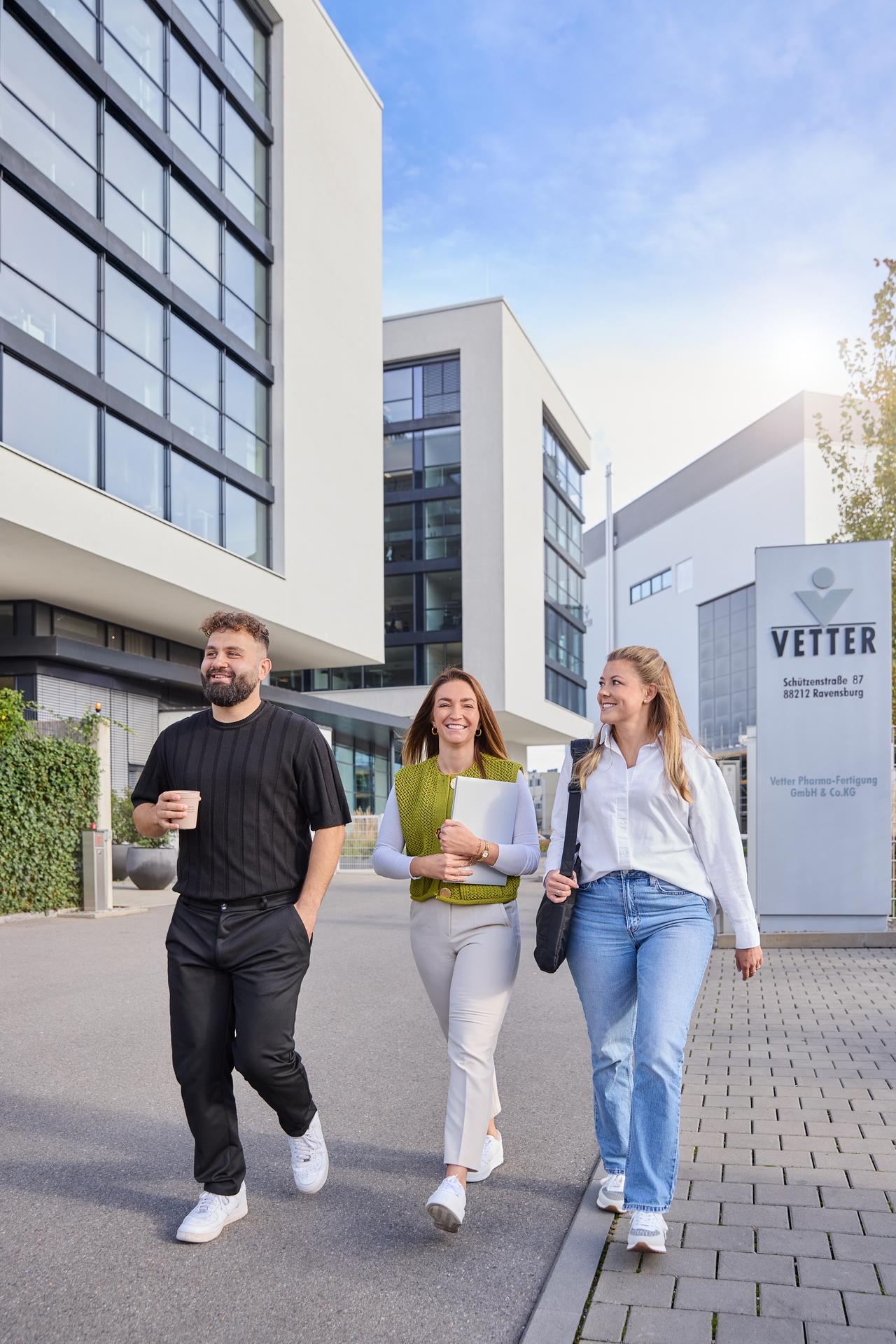 Drei Mitarbeitende gehen im Außenbereich des Vetter-Headquarters entlang