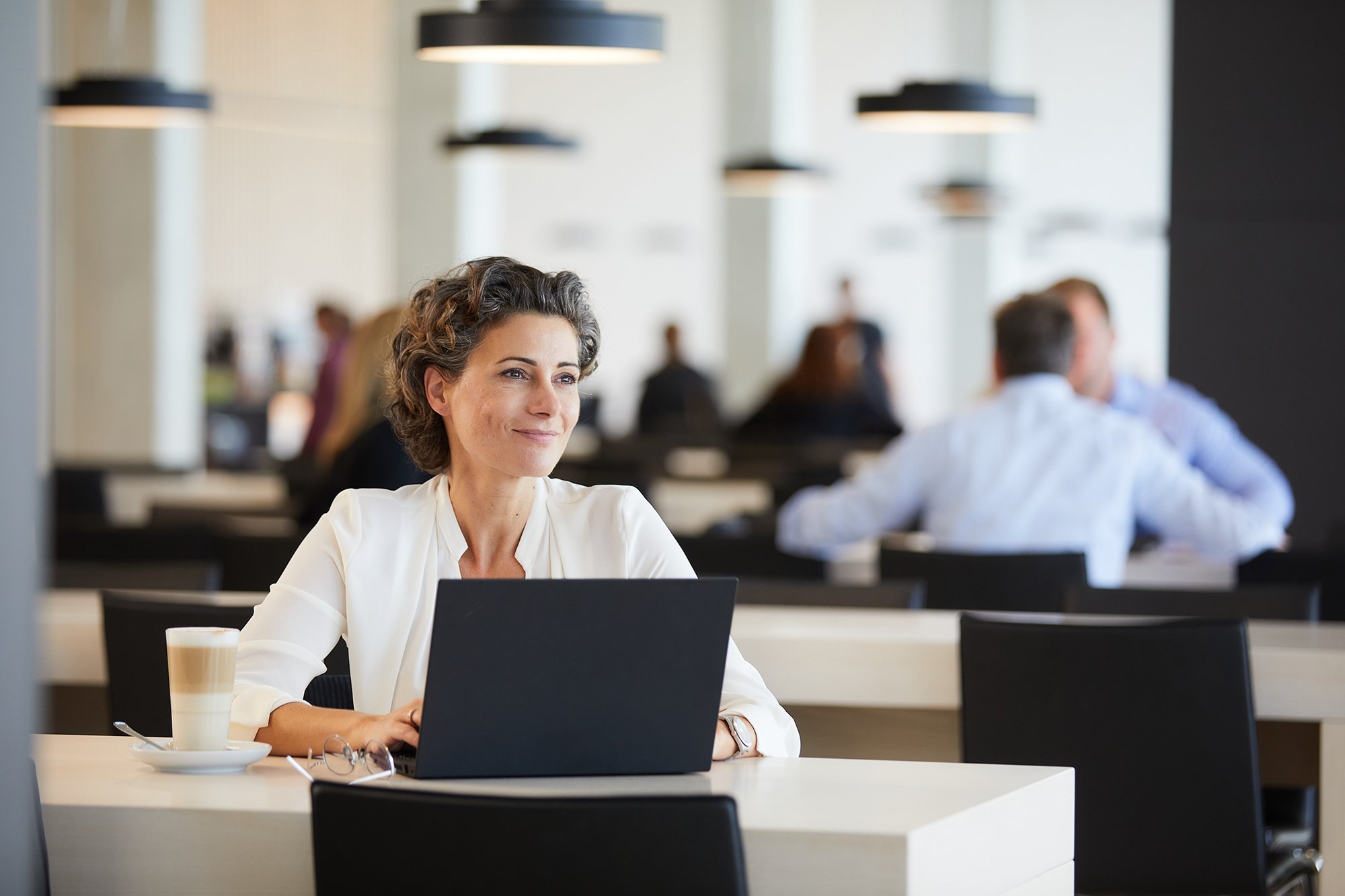 Colleague sitting on her laptop in atrium